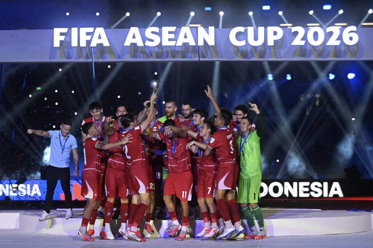 Indonesia's national men's soccer team head coach John Herdman (left) celebrates with the players during the medal ceremony of the FIFA ASEAN Cup 2026 at the Gelora Bung Karno (GBK) Stadium in Central Jakarta on Oct. 5, 2026. Indonesia wins the inaugural edition of the competition after beating Thailand 4-2 in a penalty shootout, following a 2-2 draw after extra time.