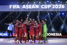 The national men's soccer team celebrates as head coach John Herdman (left) gestures on Oct. 5, 2026, during the medal ceremony of the FIFA ASEAN Cup 2026 at the main stadium of the Gelora Bung Karno Sports Complex in Central Jakarta, after routing Thailand 4-2 in a penalty shootout to win the inaugural tournament.