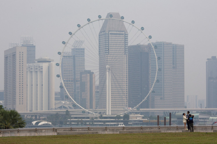 The Singapore Flyer and commercial buildings are shrouded in haze at the Marina Bay area in Singapore, on Sept. 15, 2026. 