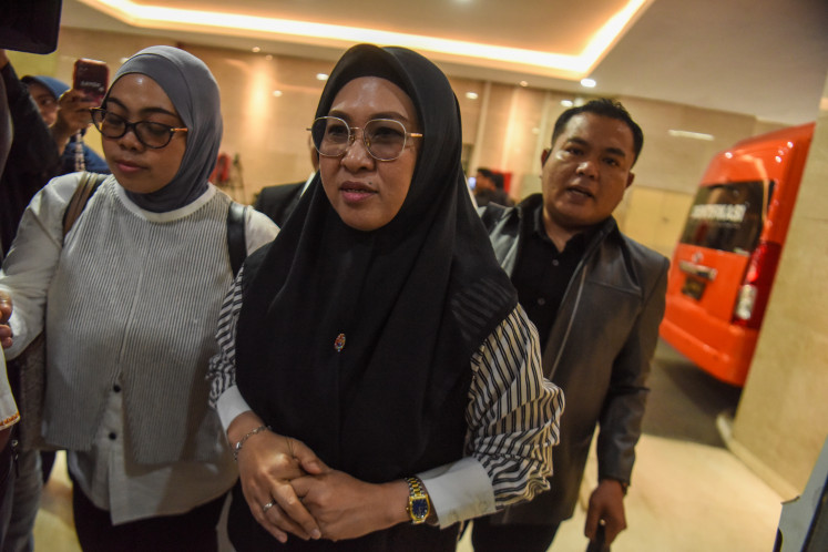Gowa Regent Sitti Husniah Talenrang (center) walks to an examination room on Oct. 1 after arriving at the National Police Criminal Investigation Department (Bareskrim) headquarters in Jakarta. Husniah was questioned as a suspect in four separate cases involving alleged corruption, extortion and money laundering.


