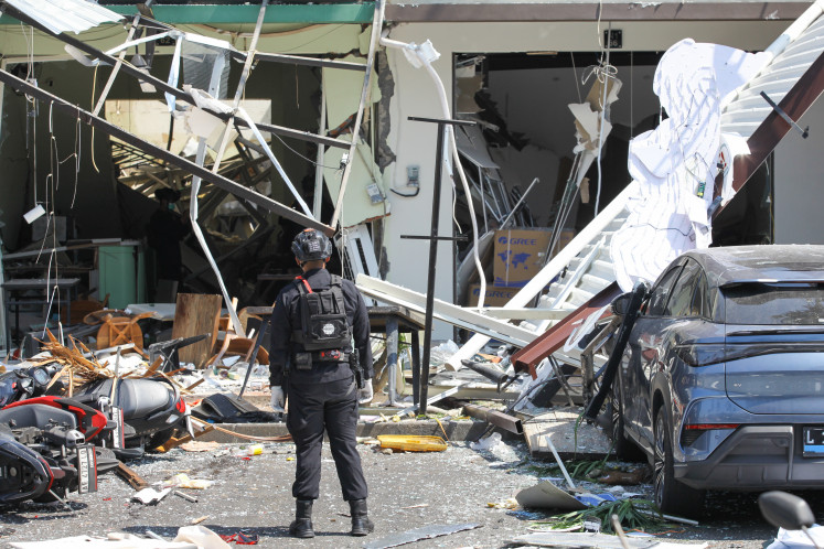 Personnel from the East Java Regional Police&rsquo;s Gegana bomb squad inspect the site of an explosion on Oct. 6 at a shopping street in Pakuwon City, Surabaya, East Java. The blast injured five people, and police said an initial investigation indicated that it was caused by an LPG leak at a restaurant.