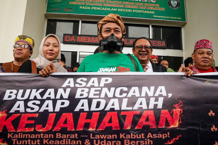 Members of the Nafas Kalbar Alliance hold a banner that reads &ldquo;haze is not a natural disaster, haze is a crime&ldquo; outside the Pontianak District Court in Pontianak, West Kalimantan, on October 7, 2026. The government was accused of &ldquo;gross negligence&ldquo; October 7 in a court case brought by residents against the president and others over a toxic haze from wildfires blanketing parts of Borneo island.