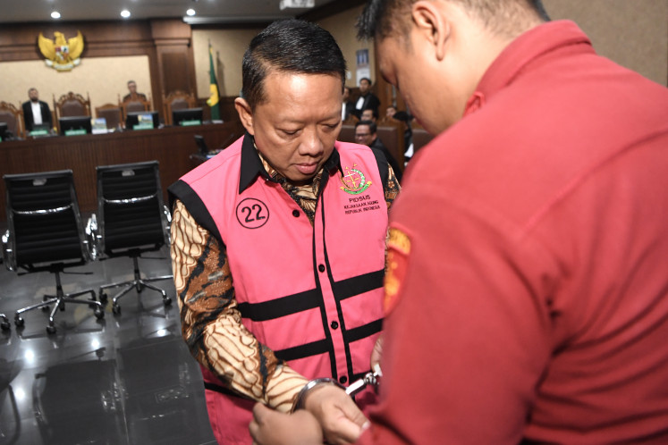 Defendant Febrie Adriansyah (left) prepares to attend his indictment hearing on Oct. 7 at the Jakarta Corruption Court. The former deputy attorney general for special crimes was charged with allegedly receiving Rp 55 billion (US$3.3 million) in connection with an extortion and money-laundering case involving Rp 354 billion.