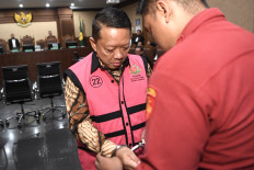 Defendant Febrie Adriansyah (left) prepares to attend his indictment hearing on Oct. 7 at the Jakarta Corruption Court. The former deputy attorney general for special crimes was charged with allegedly receiving Rp 55 billion (US$3.3 million) in connection with an extortion and money-laundering case involving Rp 354 billion.