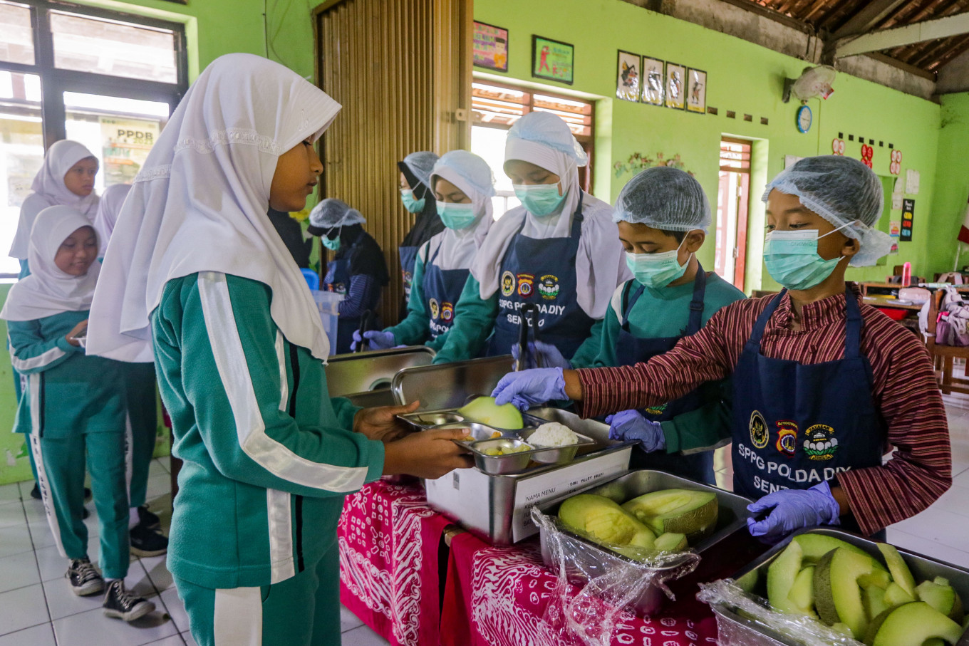 A student serves cut melon to a classmate during a trial of a buffet-style system for the free nutritious meal program on Oct. 8 at Muhammadiyah Bantar Elementary School in Sentolo, Kulon Progo, Yogyakarta. The National Nutrition Agency (BGN) is developing the buffet-style system, involving students in scheduled food service to test the effectiveness of serving meals that are warmer and fresher while reducing food waste. 