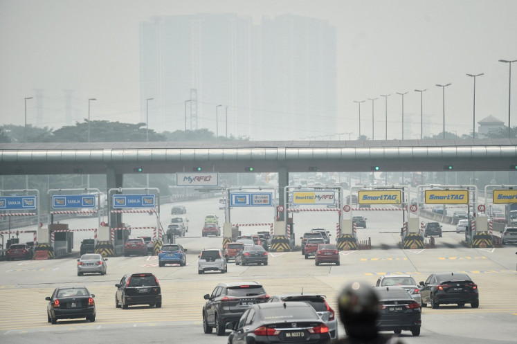 Traffic moves along a highway amid hazy condition in Kuala Lumpur on October 9, 2026. Toxic haze has shrouded parts of Indonesia, Malaysia and Singapore for weeks as Jakarta struggles to contain fires that have scorched large tracts of Borneo and Sumatra, with the smoke drifting across the region.
