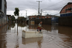 Sander Diego uses a damaged refrigerator as a boat to carry groceries on a flooded street in Porto Alegre, Rio Grande do Sul, Brazil on May 26, 2024. Brazilian prosecutors on October 9, 2026, filed an unprecedented lawsuit against oil giant Shell's subsidiary in the country, demanding US$108 million in compensation over deadly 2024 floods.