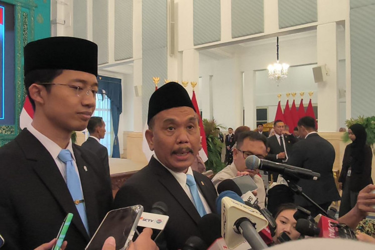 Government Communications Agency (Bakom) head Syahganda Nainggolan (right) talks to reporters on Oct. 2 at the State Palace following the inauguration of presidential advisors.
