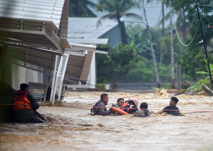 A search and rescue team from the West Sumatra Police&rsquo;s Mobile Brigade (Brimob) evacuates residents on Oct. 10 as flash floods hit the Lumin Park area in Padang, West Sumatra. Flash floods inundated several subdistricts in Padang following heavy rainfall on Saturday afternoon, affecting residential areas and prompting authorities to evacuate residents to safer locations.