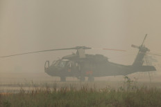 A Sikorsky UH-60 Black Hawk firefighting helicopter operated by the National Disaster Management Agency (BNPB) sits on the tarmac enveloped in haze on Sept. 24 at Tjilik Riwut Airport in Palangka Raya, Central Kalimantan. Low visibility caused by persistent forest fires has hampered both commercial air travel and aerial firefighting operations across the province.