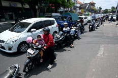 Motorcyclists queue to refuel on Wednesday at a gas station in Denpasar amid a fuel supply shortage on Indonesia's resort island of Bali.