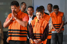 The National Disaster Mitigation Agency (BNPB) official Gabriel Purwaka Sigit (left), Bima Setiawan (right) who is the younger brother of BNPB chief Suharyanto, and private-sector figure Syifa Nrika Ghifarian (second left) walk in detainee vests after questioning at the Corruption Eradication Commission (KPK) headquarters in Jakarta on Wednesday (Oct. 14, 2026). The KPK has detained five suspects in an alleged corruption case at BNPB, uncovered through a sting operation.