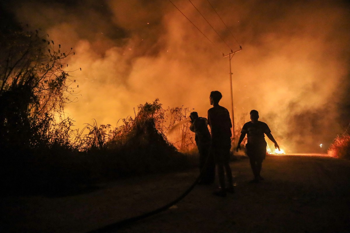 Firefighters work to contain a wildfire on Oct. 13 in Banjarbaru, South Kalimantan.