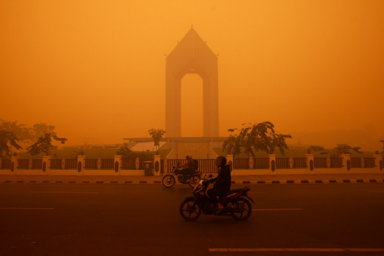 Motorcyclists ride in the morning in Palangka Raya, Central Kalimantan on October 14, 2026. Thick haze has turned the skies in the city into apocalyptic shades of yellow and orange on Thursday, reducing visibility to a few dozen meters as wildfires cause a regional air pollution crisis. 