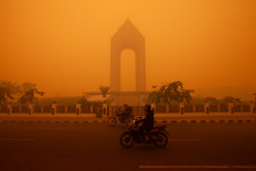 Motorcyclists ride in the morning in Palangka Raya, Central Kalimantan on October 14, 2026. Thick haze has turned the skies in the city into apocalyptic shades of yellow and orange on Thursday, reducing visibility to a few dozen meters as wildfires cause a regional air pollution crisis. 