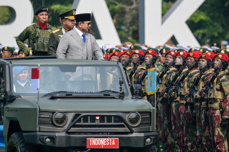 President Prabowo Subianto (right) and Indonesian Military (TNI) Commander Gen. Agus Subiyanto (center), stand in an open ceremonial vehicle labeled 'INDONESIA 1' to review the ranks during the 81st TNI Day Parade in Cilangkap, East Jakarta, on Oct. 5, 2026. 