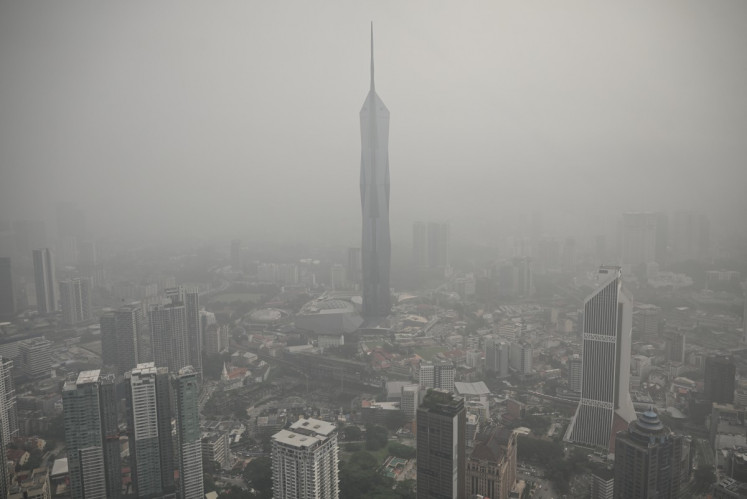 Buildings are shrouded in haze caused by fires in Indonesia, in Kuala Lumpur on October 16, 2026. Toxic haze has covered parts of Indonesia, Malaysia and Singapore for weeks as Jakarta struggles to contain fires that have scorched large tracts of Borneo and Sumatra, with the smoke drifting across the region. 