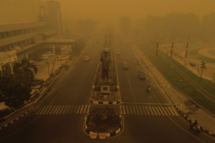 Thick smoke and haze from forest and land fires covers Palangkaraya, Central Kalimantan, on Oct. 15, 2026. Toxic haze has covered parts of Indonesia, Malaysia and Singapore for weeks as Jakarta struggles to contain fires that have scorched large tracts of Kalimantan and Sumatra, with the smoke drifting across the region. 
