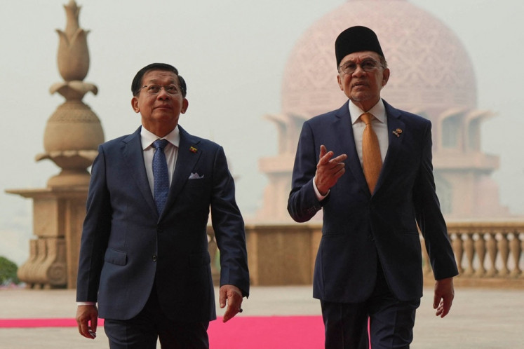 Myanmar leader Min Aung Hlaing (left) walks with Malaysia&rsquo;s Prime Minister Anwar Ibrahim during a welcome ceremony on Oct. 8 at the prime minister&rsquo;s office in Putrajaya, Malaysia.