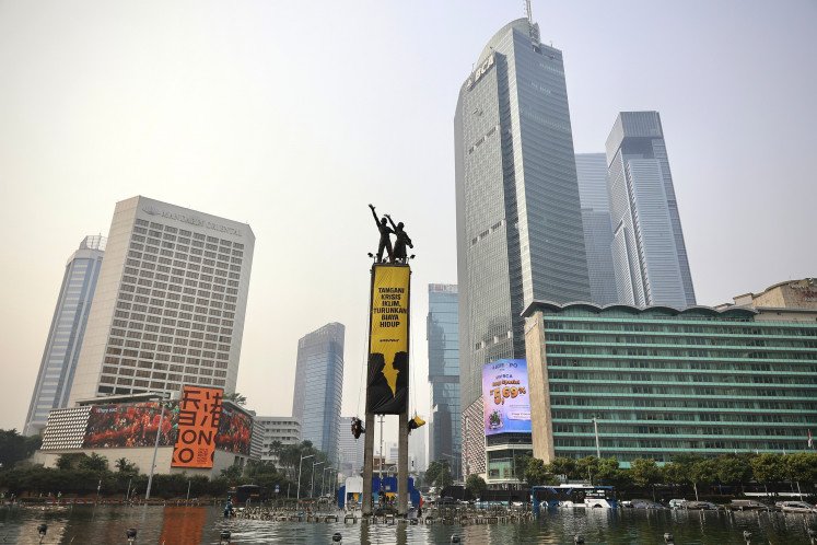 Greenpeace Indonesia activists unfurled two giant banners from the top of the Tugu Selamat Datang monumnet at the Hotel Indonesia traffic circle in Central Jakarta, on Oct. 20, 2026.