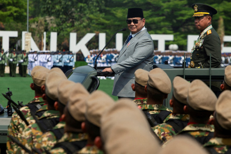 President Prabowo Subianto, accompanied by Indonesian Military (TNI) commander Gen. Agus Subiyanto, stands on a military vehicle while inspecting the troops during the 81st anniversary of the military on Oct. 5 in Cilangkap, East Jakarta. 
