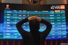 A visitor looks at an electronic display showing movements of the Indonesia Stock Exchange (IDX) Composite index on Oct. 16, 2026, at the bourse in South Jakarta.