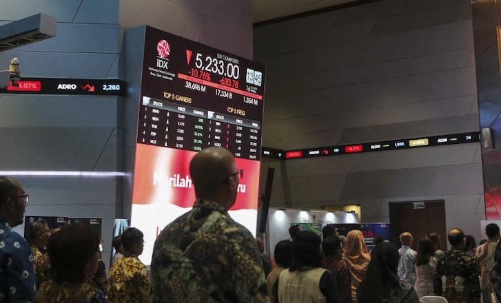 People look at a screen showing the Indonesia Composite Index after the market plunge at the stock exchange in Jakarta on Oct. 16, 2026. 