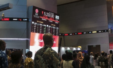 People look at a screen showing the Indonesia Composite Index after the market plunge at the stock exchange in Jakarta on Oct. 16, 2026. 