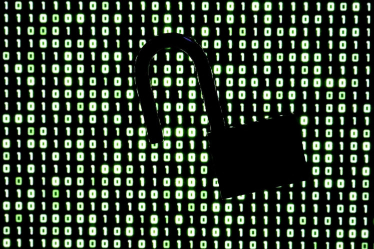 An illustration picture taken on October 21, 2026 shows a padlock in front of binary code on a laptop screen in Frankfurt am Main, western Germany. Government agencies and companies around the world shut down websites on October 21, 2026 after two critical flaws came to light involving PHP, a programming language that is the basis for a large share of the internet. 