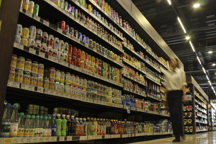 A customer passes by a rack of sweetened drinks in a retail supermarket in Jakarta on Dec. 14, 2023. A survey from the Indonesian Consumers Foundation (YLKI) revealed that 58 percent of 800 respondents support the plan to impose excise tax on sweetened beverages to control their consumption and prevent diabetes prevalence in children, which increased 70-fold in 2023 compared with 2010. 