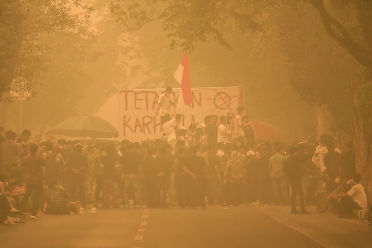 Demonstrators gather amidst heavy haze during a protest demanding action over forest and land fires outside the Central Kalimantan Governor's office in Palangka Raya on October 23, 2026. 