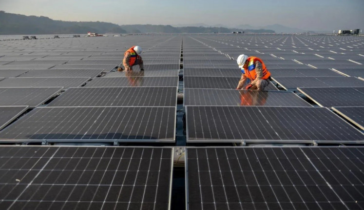 Final tweaks: Technicians check panels on Sept. 29, 2023, at the Cirata floating solar photovoltaic plant, located at the Cirata Reservoir in Purwakarta, West Java. 