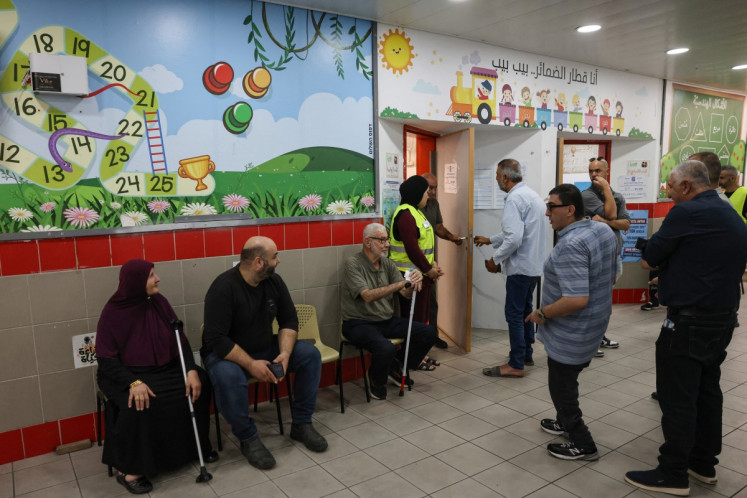 People wait before casting their ballot to vote at a polling station in the Arab-Israeli town of Umm al-Fahm on October 27, 2026, on the day of Israel's legislative election.