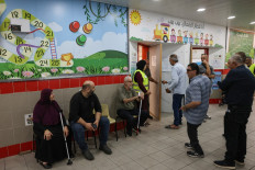 People wait before casting their ballot to vote at a polling station in the Arab-Israeli town of Umm al-Fahm on October 27, 2026, on the day of Israel's legislative election.