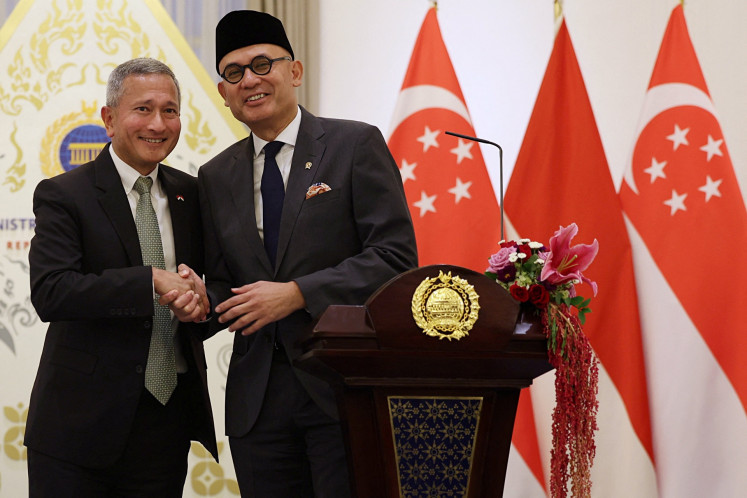 Foreign Minister Arrmanatha Nasir (right) shakes hands with Singapore Foreign Minister Vivian Balakrishnan on Tuesday after a press briefing at the Foreign Ministry's office in Central Jakarta.
