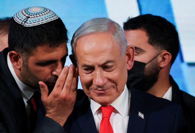 An aide speaks to Israeli Prime Minister and Likud party leader Benjamin Netanyahu as he gives a statement following exit polls for Israel's national election, at Likud's election headquarters in Jerusalem, October 28, 2026.