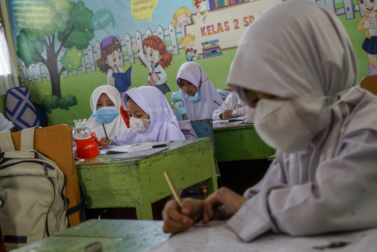 Students attend a class on Oct. 19 at state elementary school SDN 6 Pekanbaru in Riau. The Pekanbaru administration has resumed in-person classes for elementary and junior high school students, requiring them to wear masks as air quality improves after forest and peatland fire haze forced schools to switch to distance learning. 