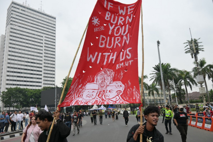 Protesters hold a large red banner reading &ldquo;If we burn, you burn with us&ldquo; during a protest against economic hardship, graft and the government's handling of devastating wildfires causing toxic haze that has sickened thousands in Jakarta on Oct. 28, 2026.