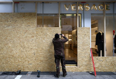A worker secures a Versace store with wooden boards ahead of expected protests by the youth movement &ldquo;Gen Z regelt&ldquo; in Frankfurt, Germany, on Oct. 30, 2026.